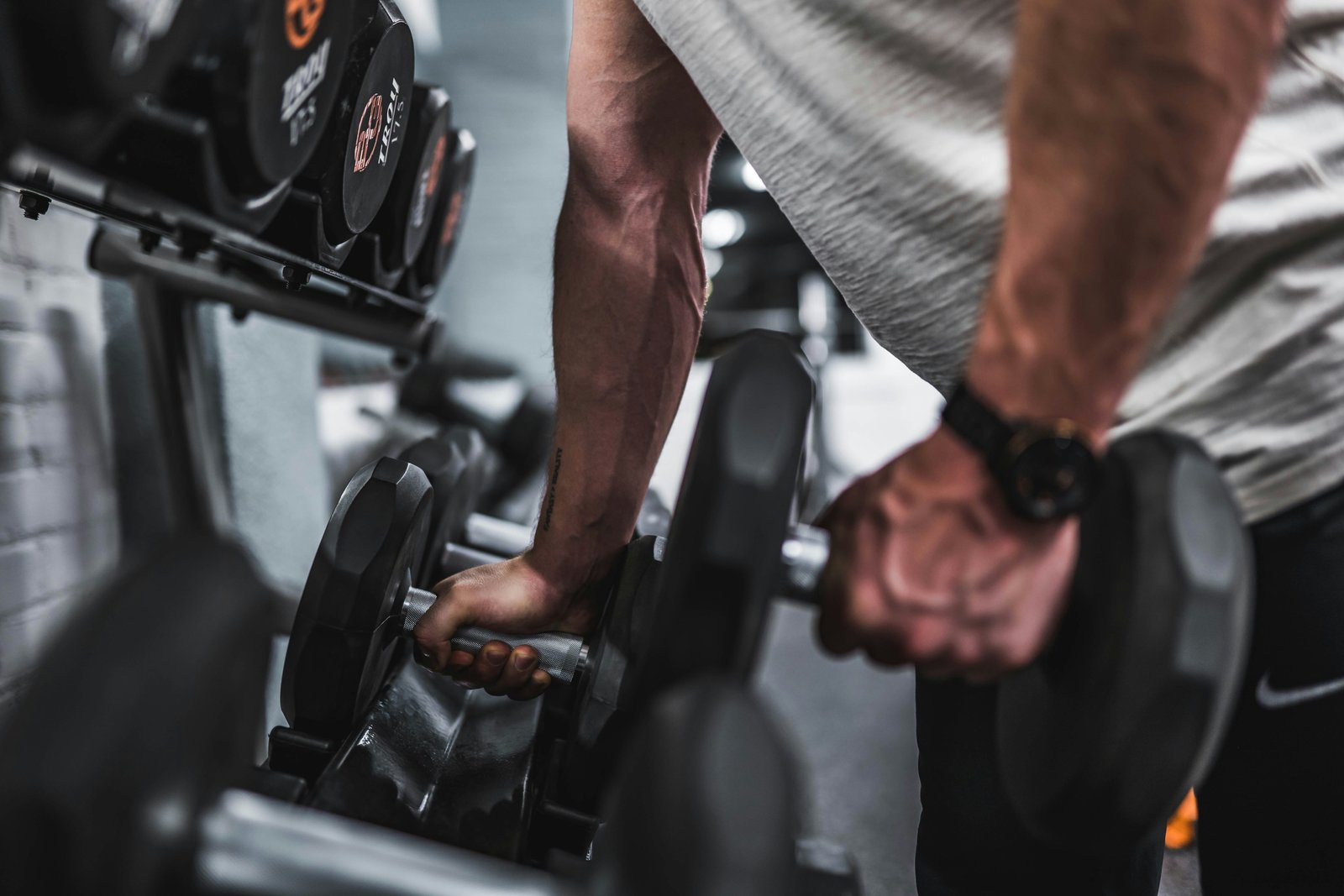 Athlète confirmé soulevant une barre chargée en salle de musculation