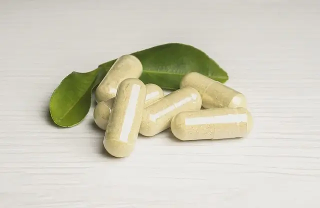 Gélules de plantes et zinc sur fond noir, avec homme en fond motivé après l'entraînement