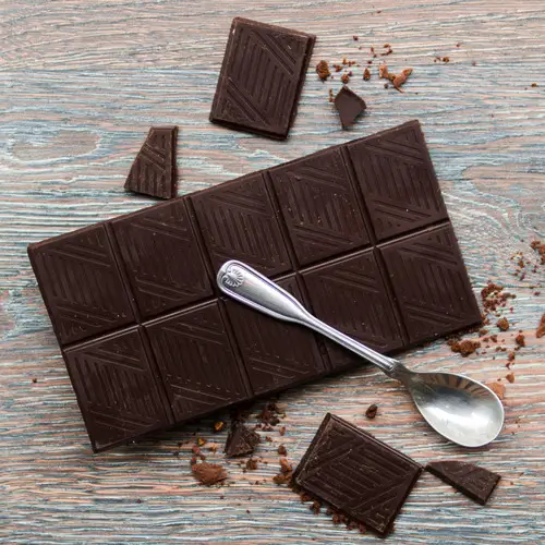 Carrés de chocolat noir 85 % sur table en bois
