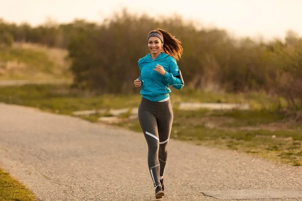 Femme souriante en jogging, au lever du soleil, après séance de sport anti-déprime