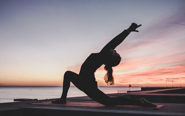 femme faisant du yoga au coucher du soleil, sport du soir pour bien dormir