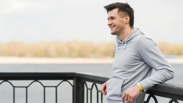 Homme la quarantaine souriant après séance de sport en plein air, lien sport mémoire après 40 ans